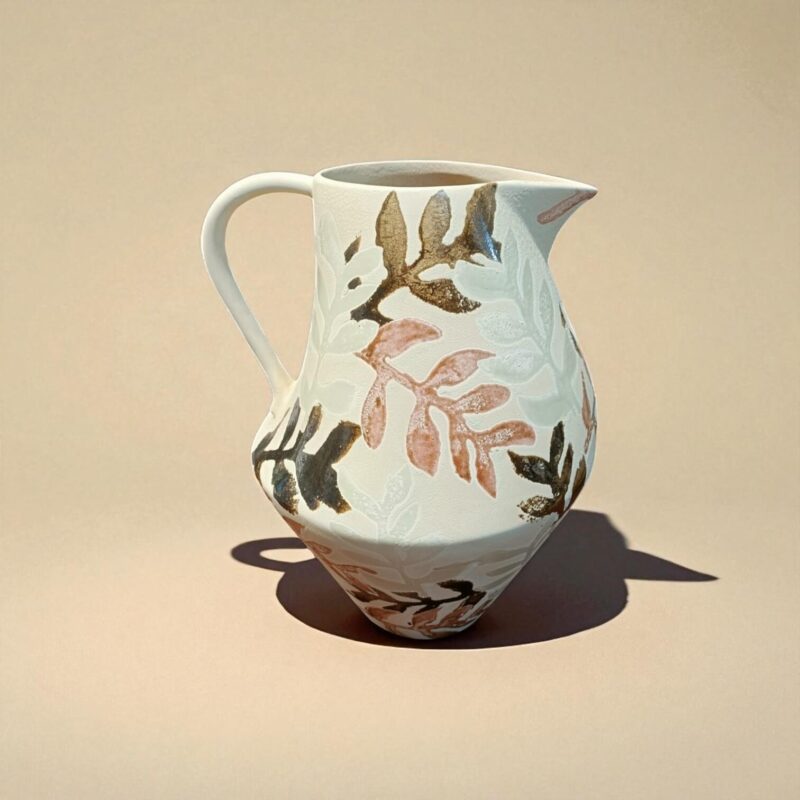 Jarra de cerámica "Hojarasca" vista de perfil, mostrando el asa y el patrón de hojas pintadas. De la tienda Portugal Home en Sevilla.